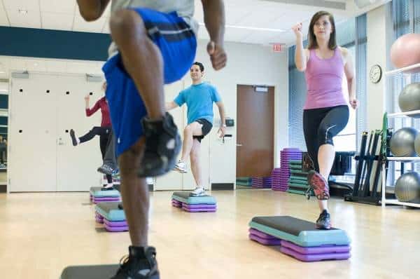 Individuals exercising during an energetic indoor fitness class.