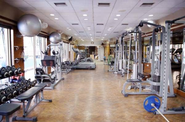 Spacious, well-equipped fitness centre with modern machines and clean, light-coloured floor.
